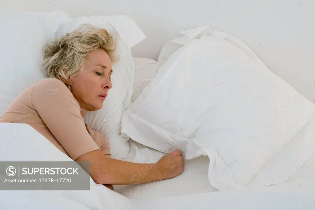 Mature woman sleeping in bed