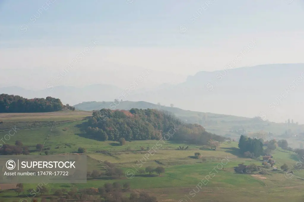 Rural landscape with fog and mountains in the distance
