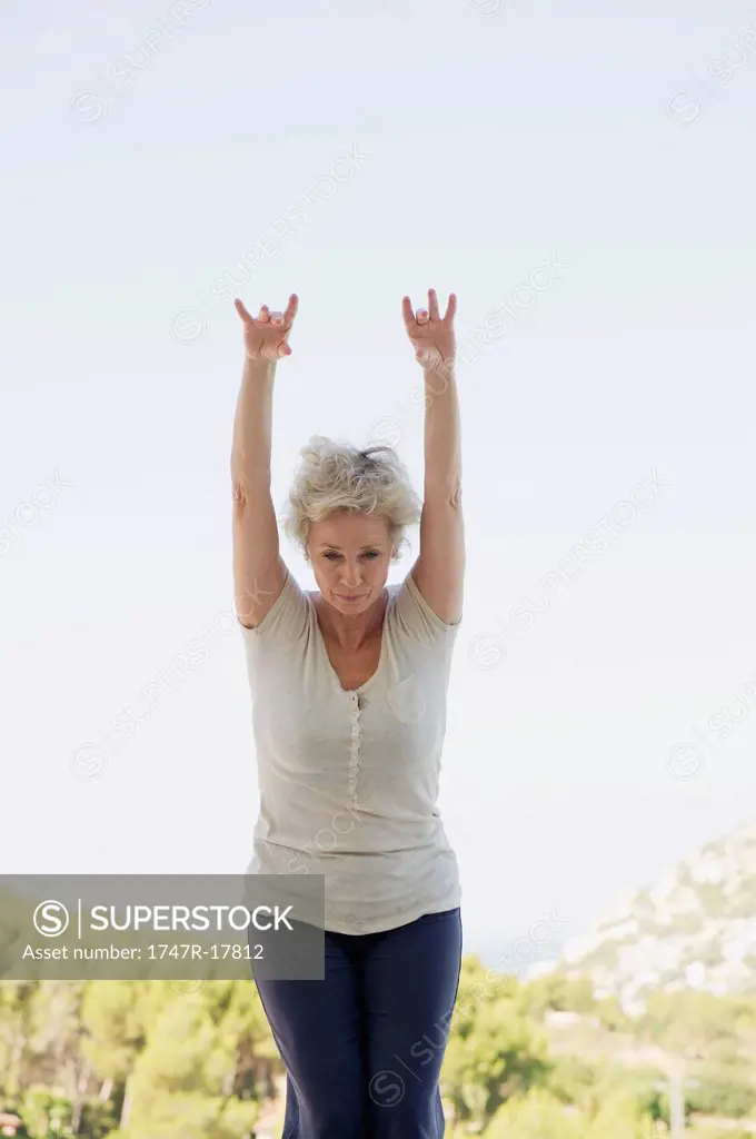 Mature woman doing sun salutation pose