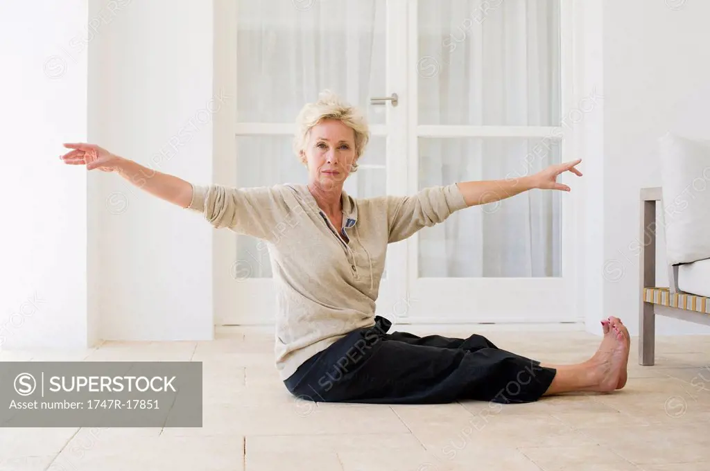 Mature woman practicing yoga on floor