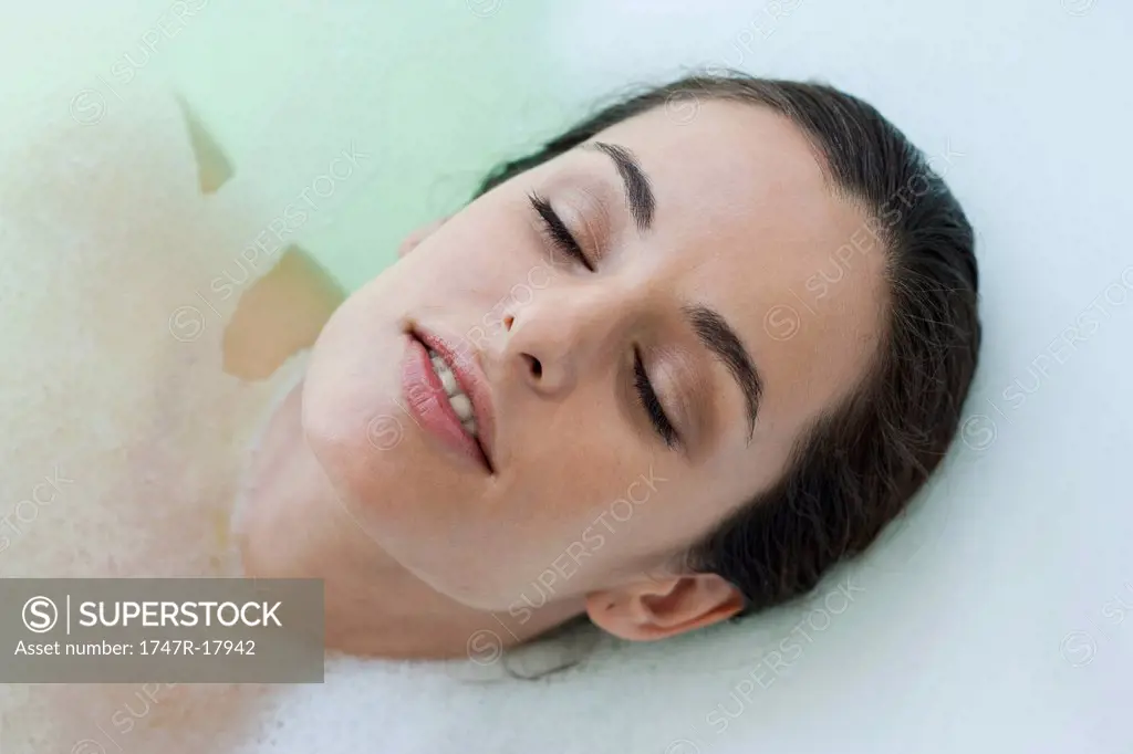 Woman relaxing in bath with eyes closed