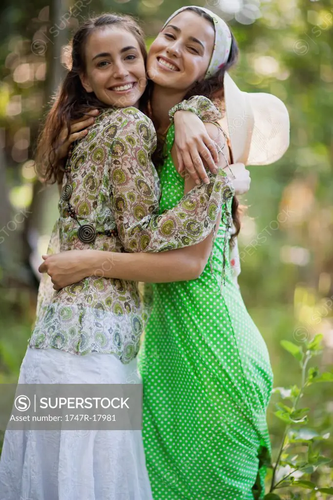 Young women embracing outdoors, portrait