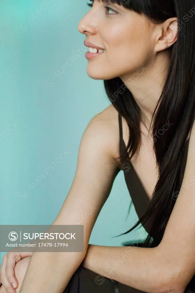 Young woman smiling and looking away in thought, portrait