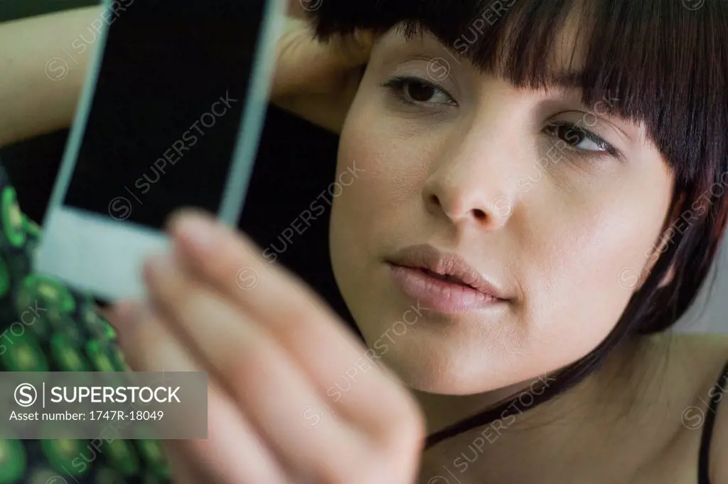 Woman looking sadly at photograph