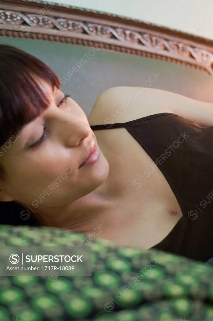 Woman lying on side, looking away in thought