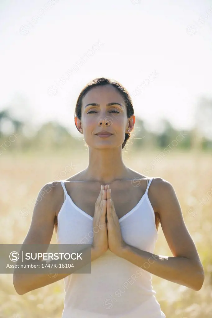 Mid_adult woman meditating outdoors