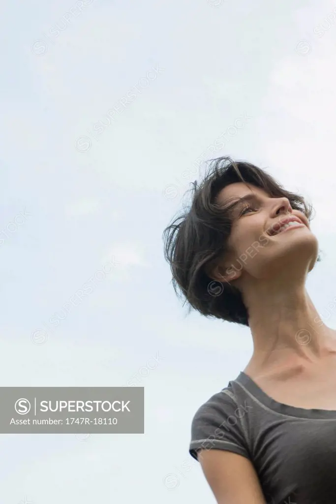 Woman smiling outdoors, low angle view