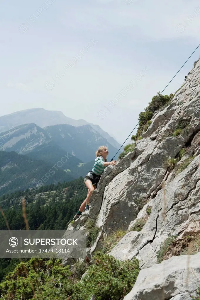 Preteen girl rock climbing