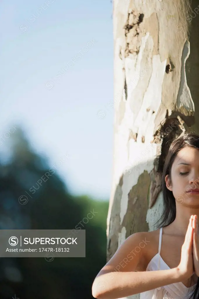 Young woman in prayer position, cropped