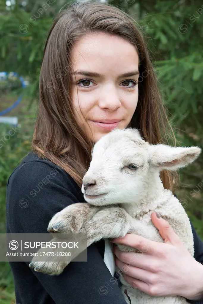 Teenage girl holding lamb