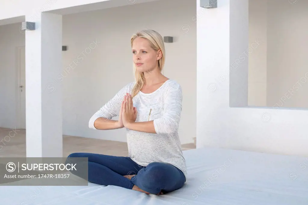 Young woman sitting in prayer positon