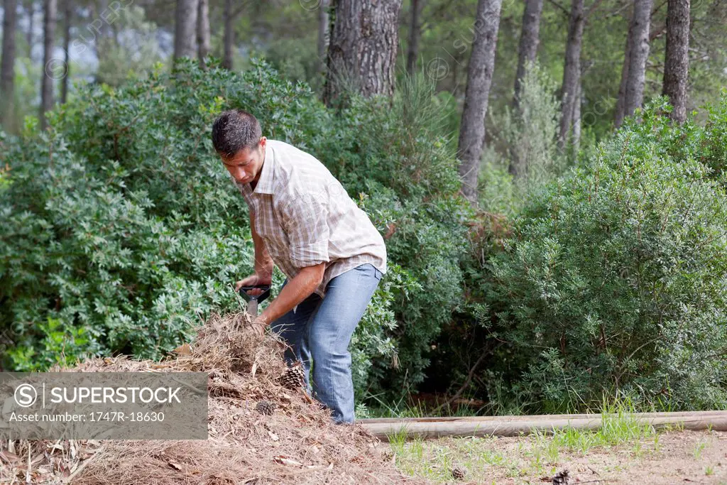 Man scooping pile of straw