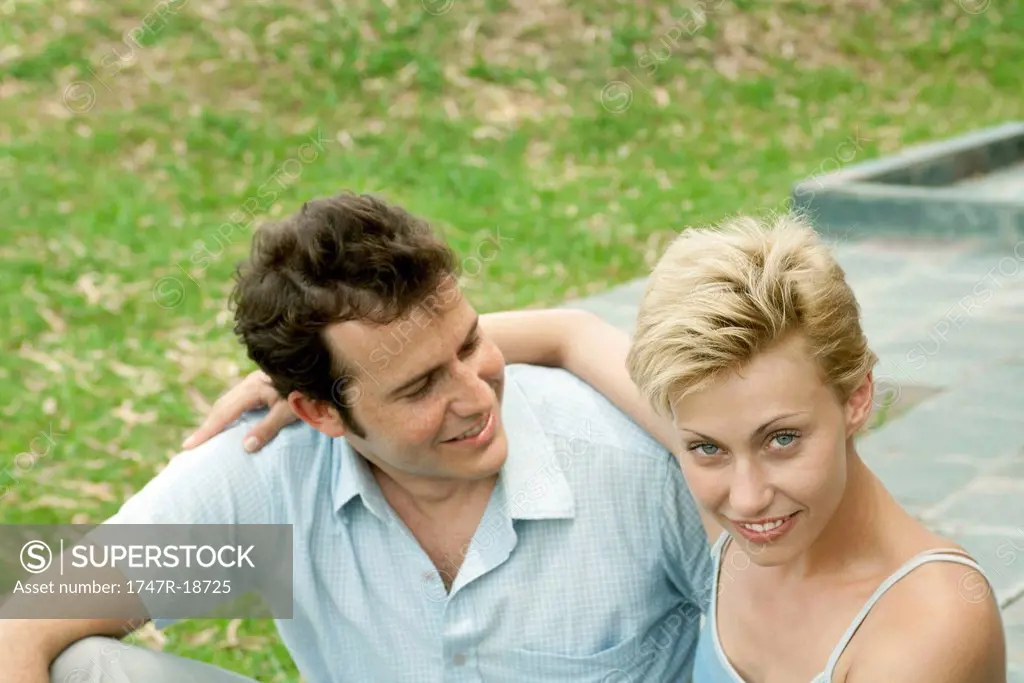 Couple sitting together outdoors, portrait