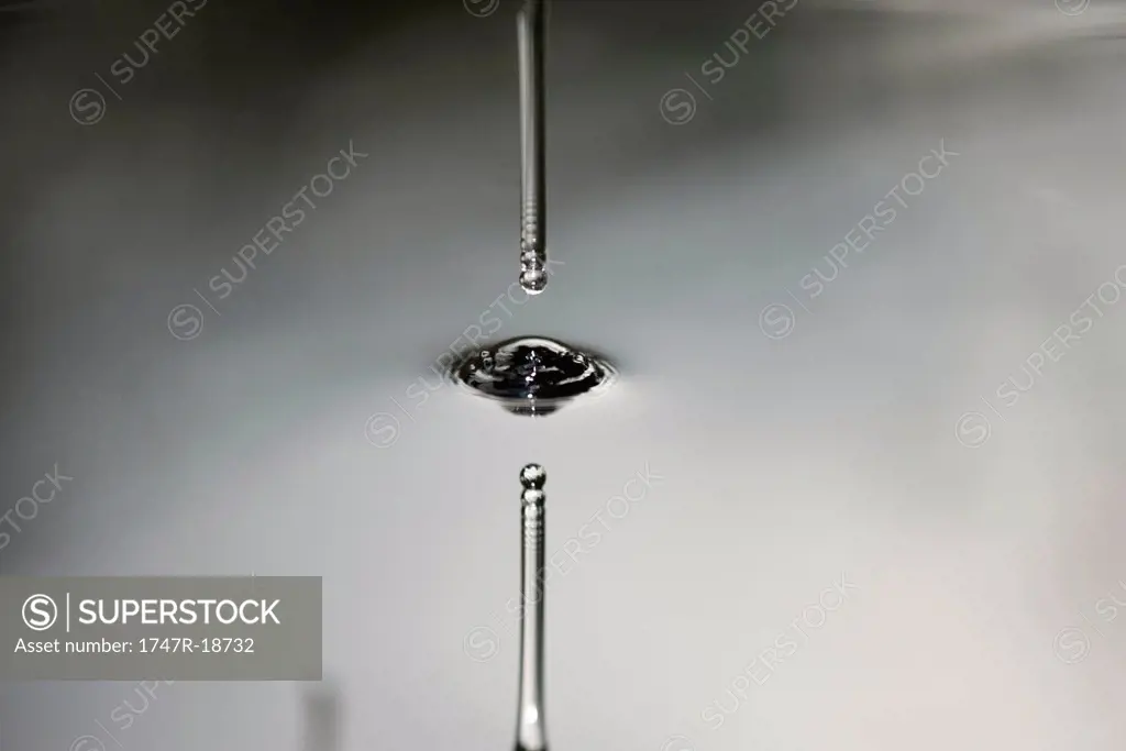 Drop hitting smooth surface of water