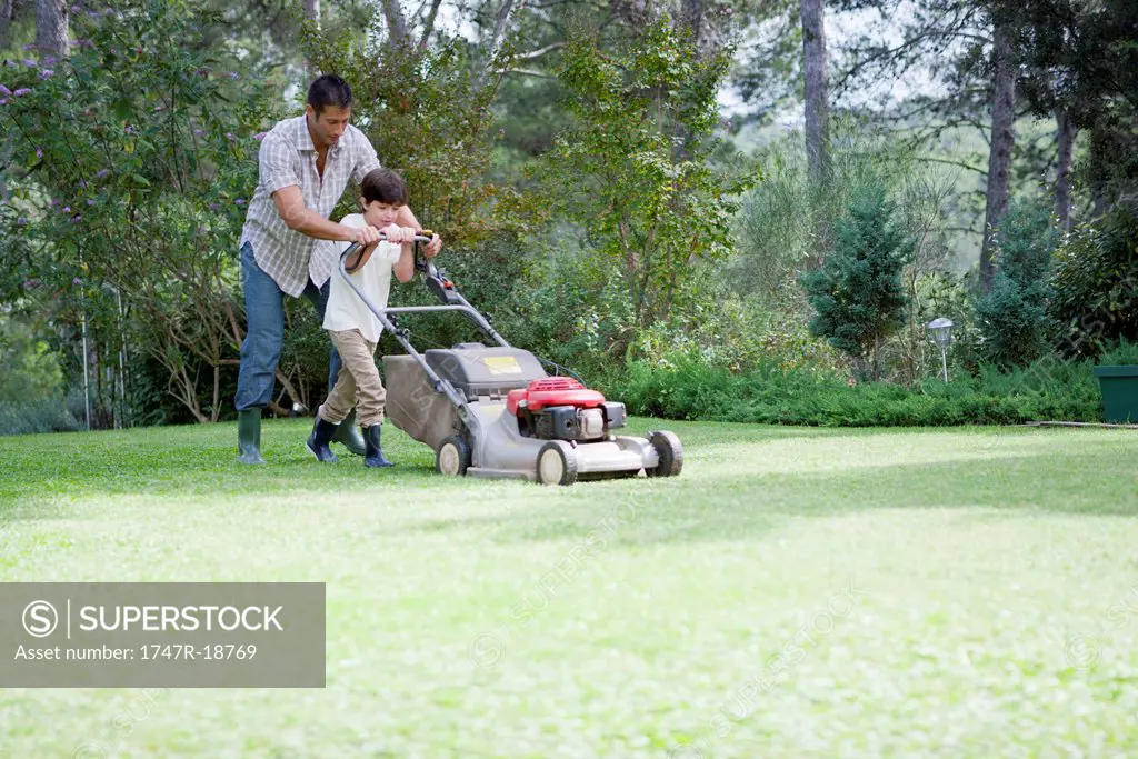 Father and son mowing lawn together