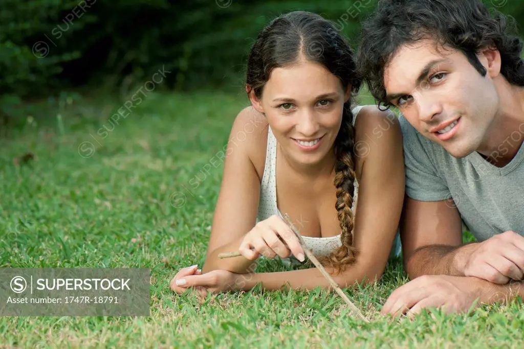 Young couple lying together on grass, portrait