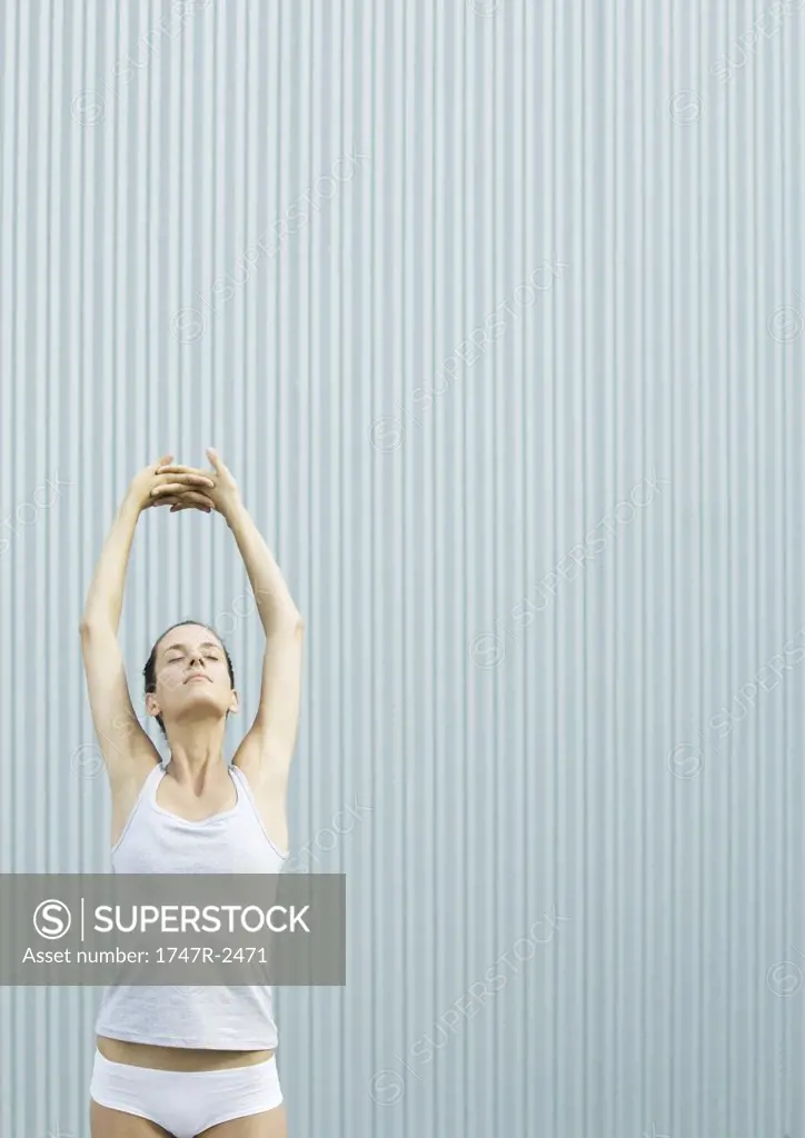Woman standing stretching arms over head