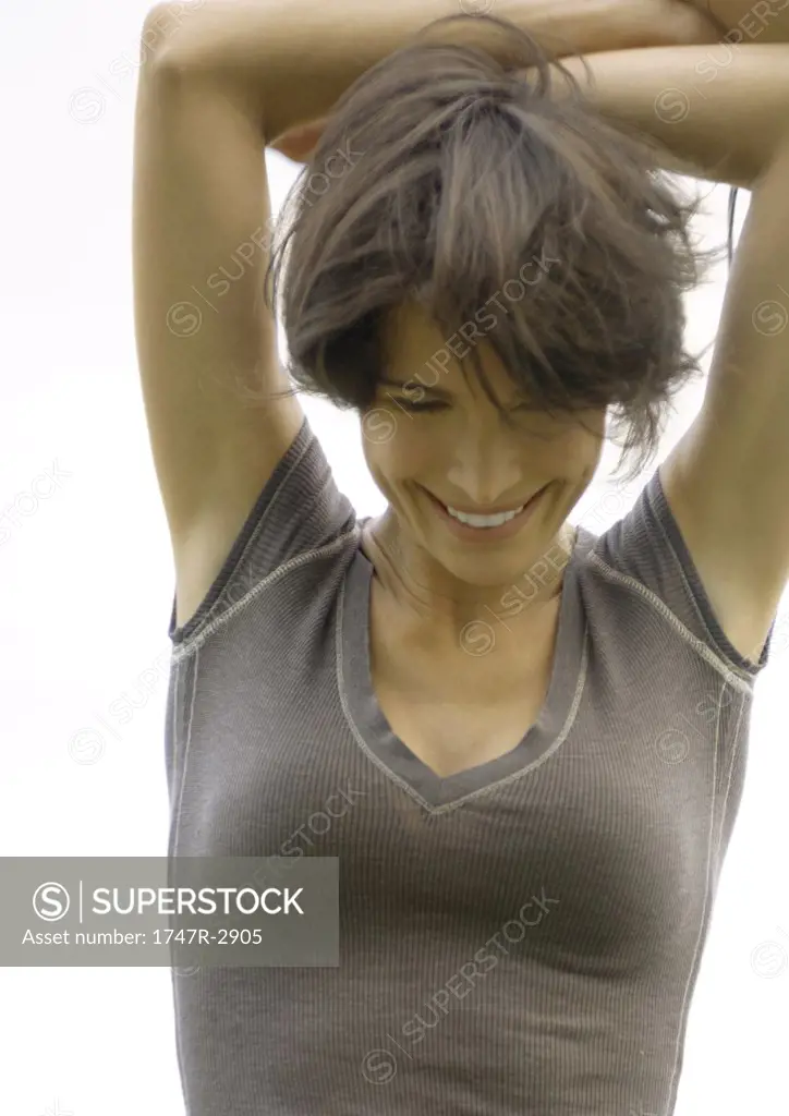 Woman with hands over head, smiling