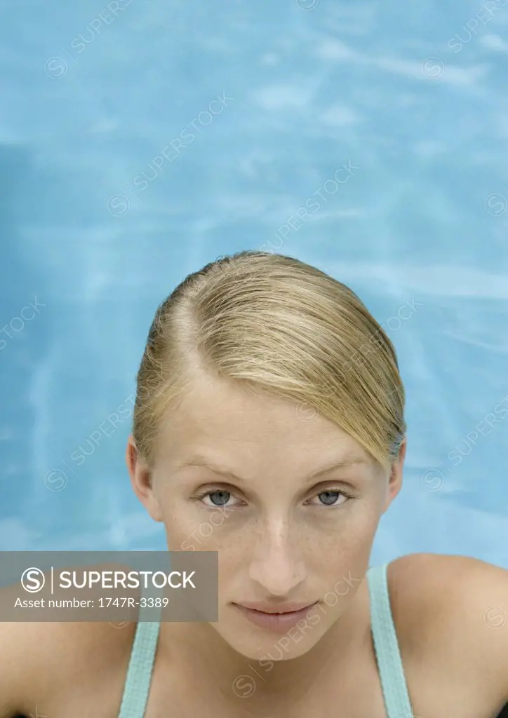 Young woman, head and shoulders, pool water in background
