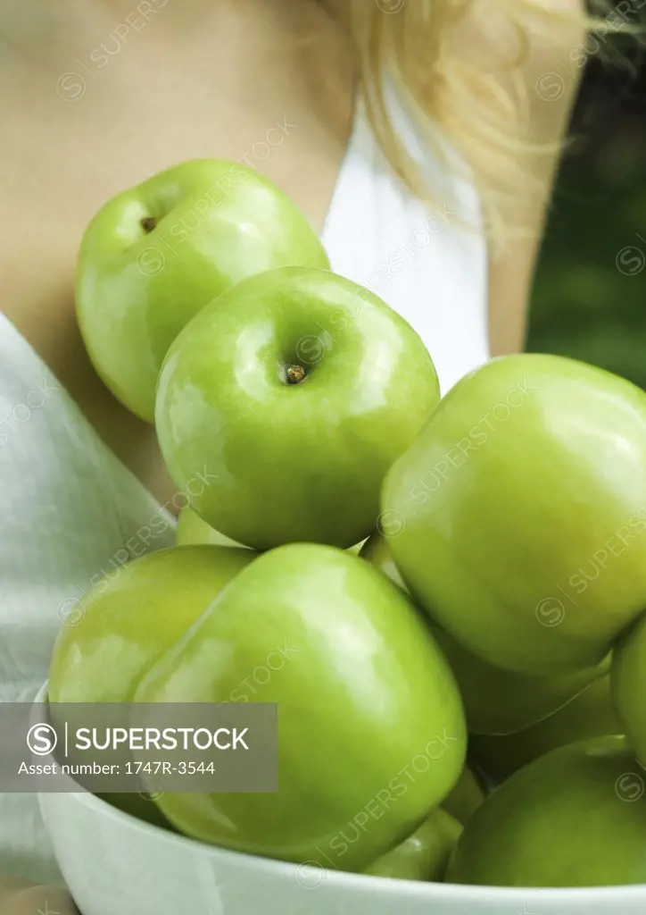Woman holding bowl of apples, close-up of apples
