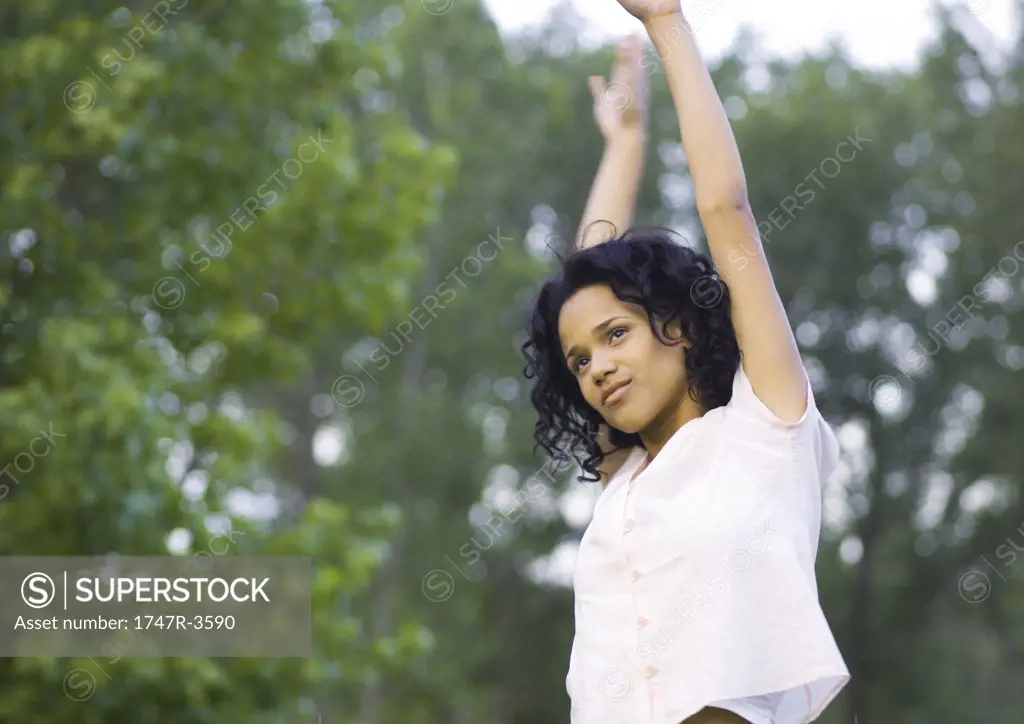 Young woman standing with arms raised