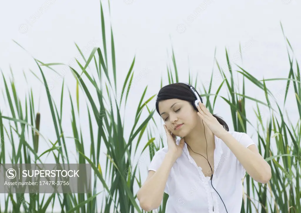 Woman listening to headphones, eyes closed