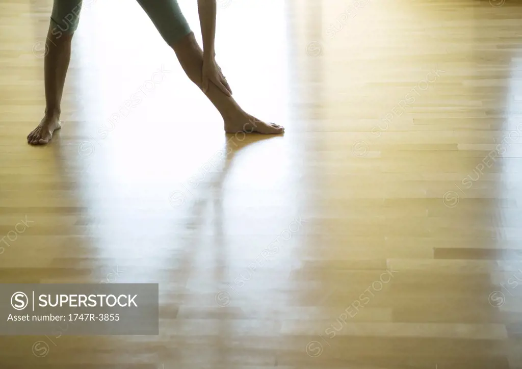 Yoga class, woman standing in triangle position, low section