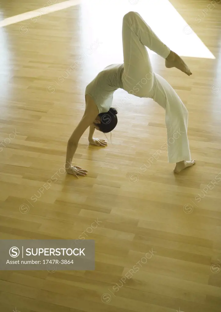 Yoga class, woman doing one-legged bridge pose
