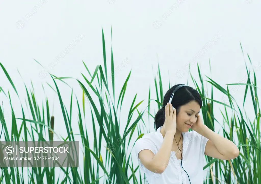 Woman listening to headphones, eyes closed