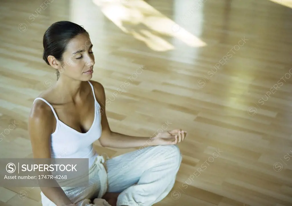 Woman sitting in lotus position with eyes closed
