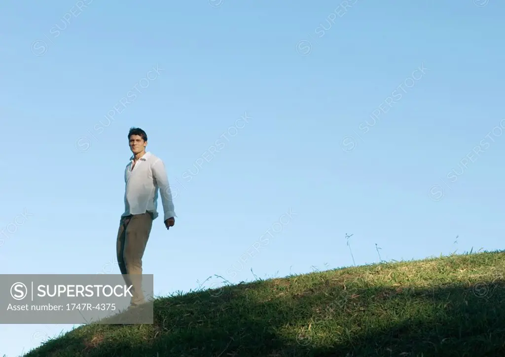 Man standing on hill, low angle view