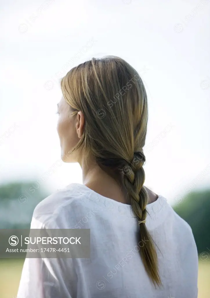Woman outdoors, hair braided, rear view