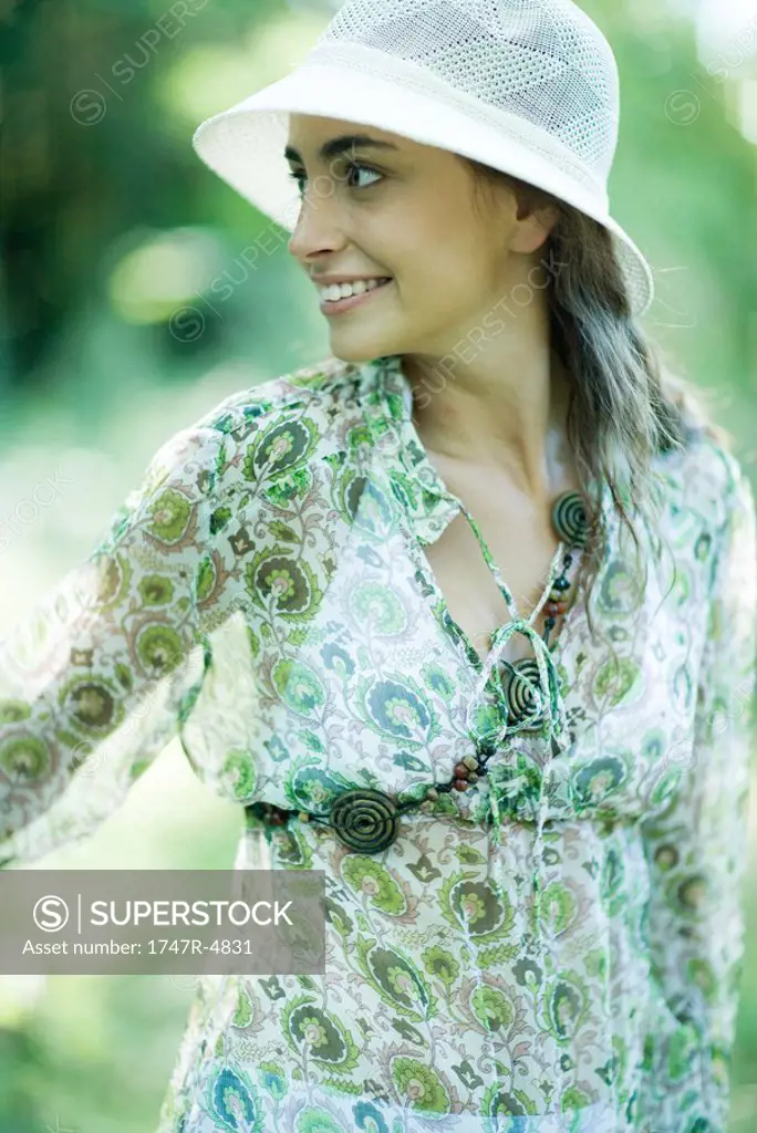 Young woman wearing sunhat, looking away, portrait