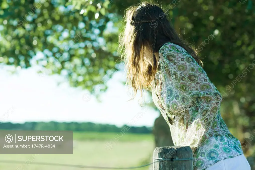 Young hippie woman looking over fence