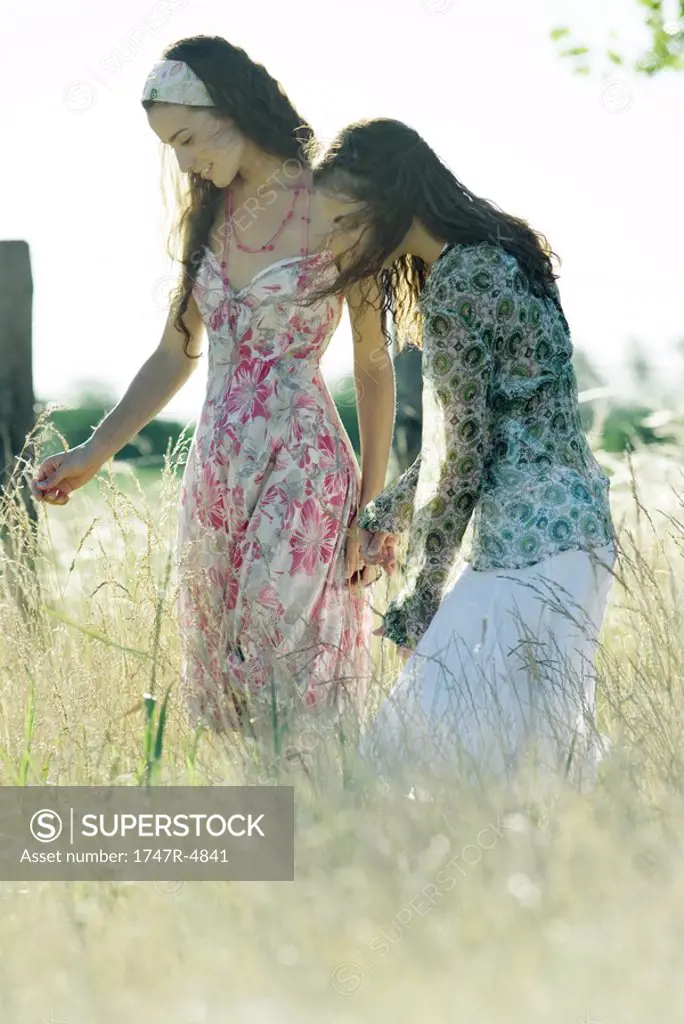 Two young women standing in field
