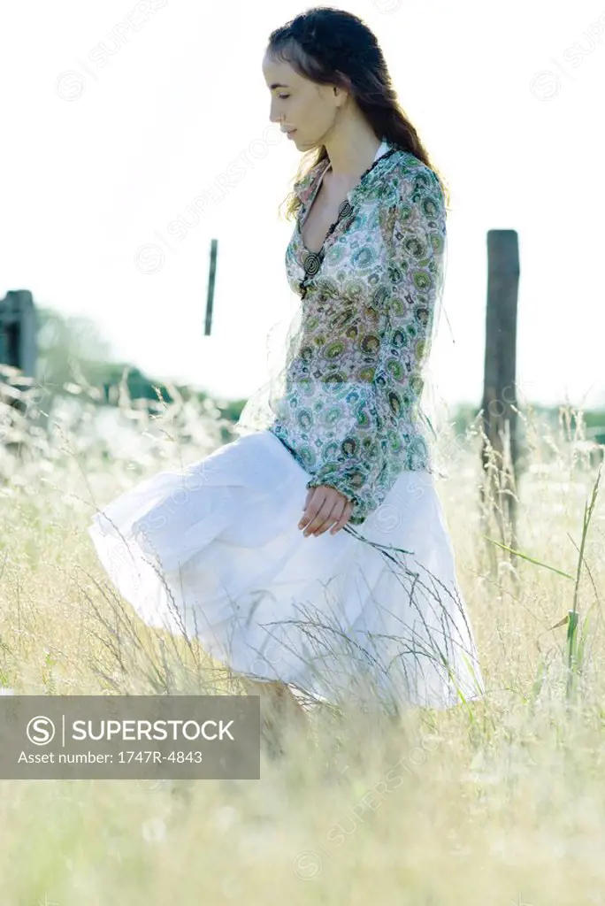 Young woman walking through field