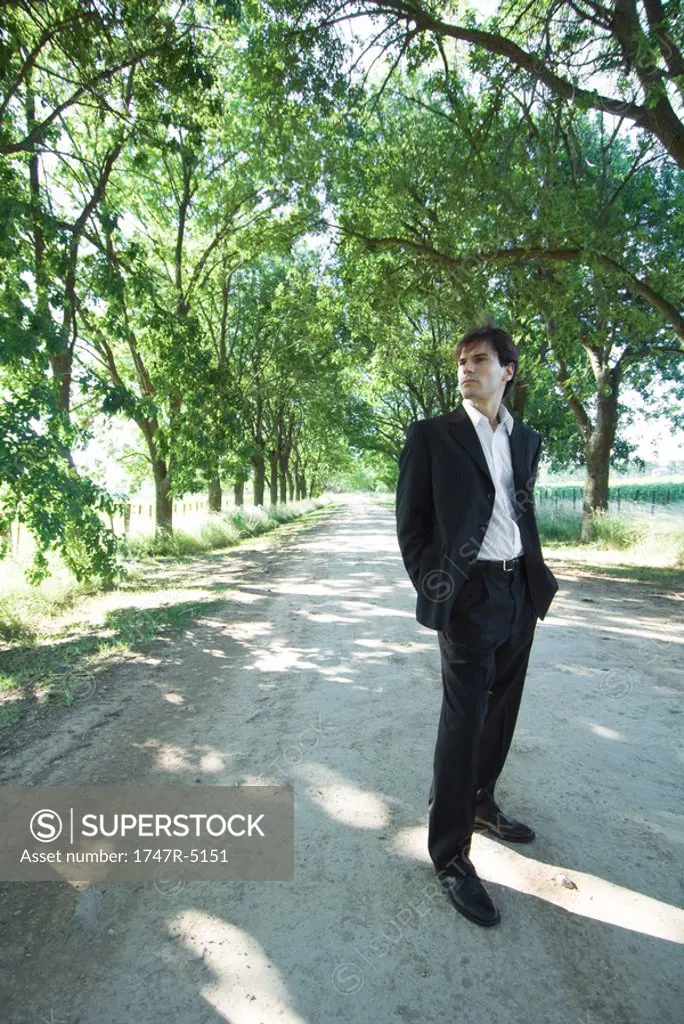 Businessman standing in rural road, full length