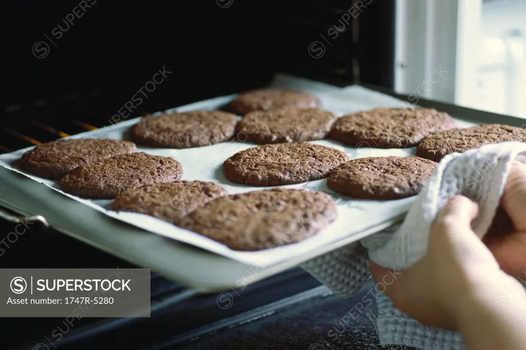 Taking sheet of cookies out of the oven