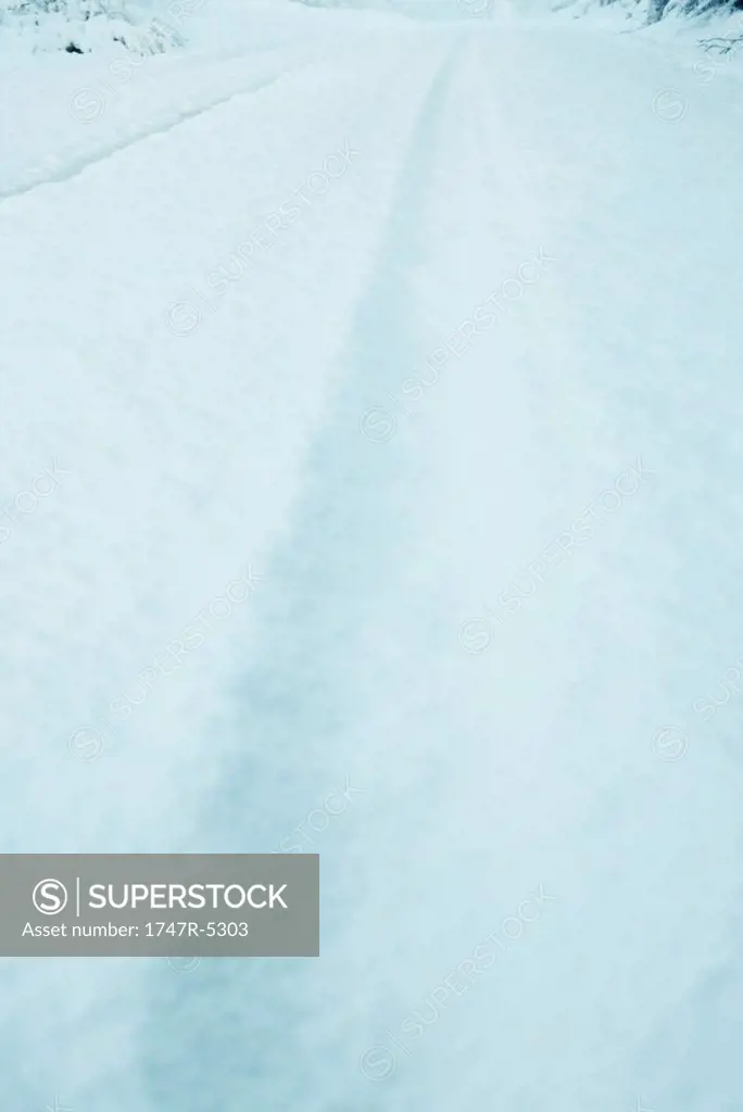 Snow falling over snow-covered road, close-up