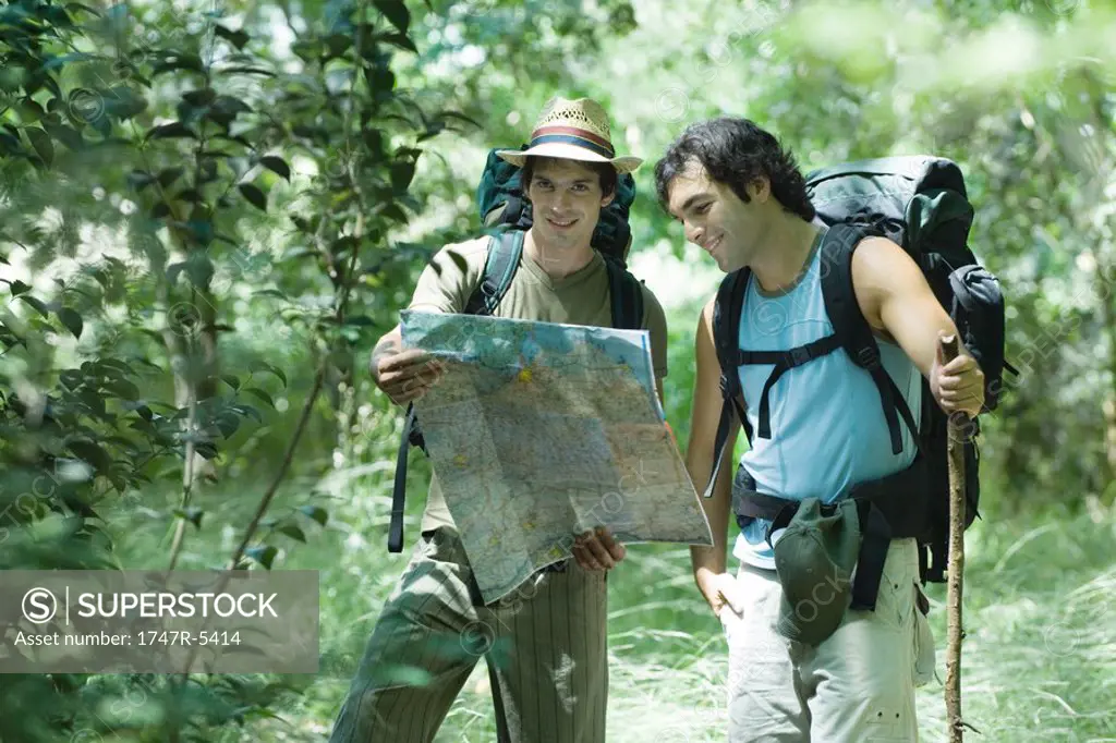 Hikers standing, looking at map