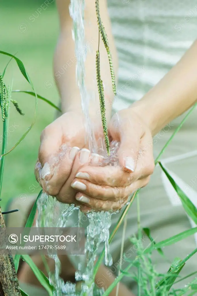 Woman´s cupped hands under running water