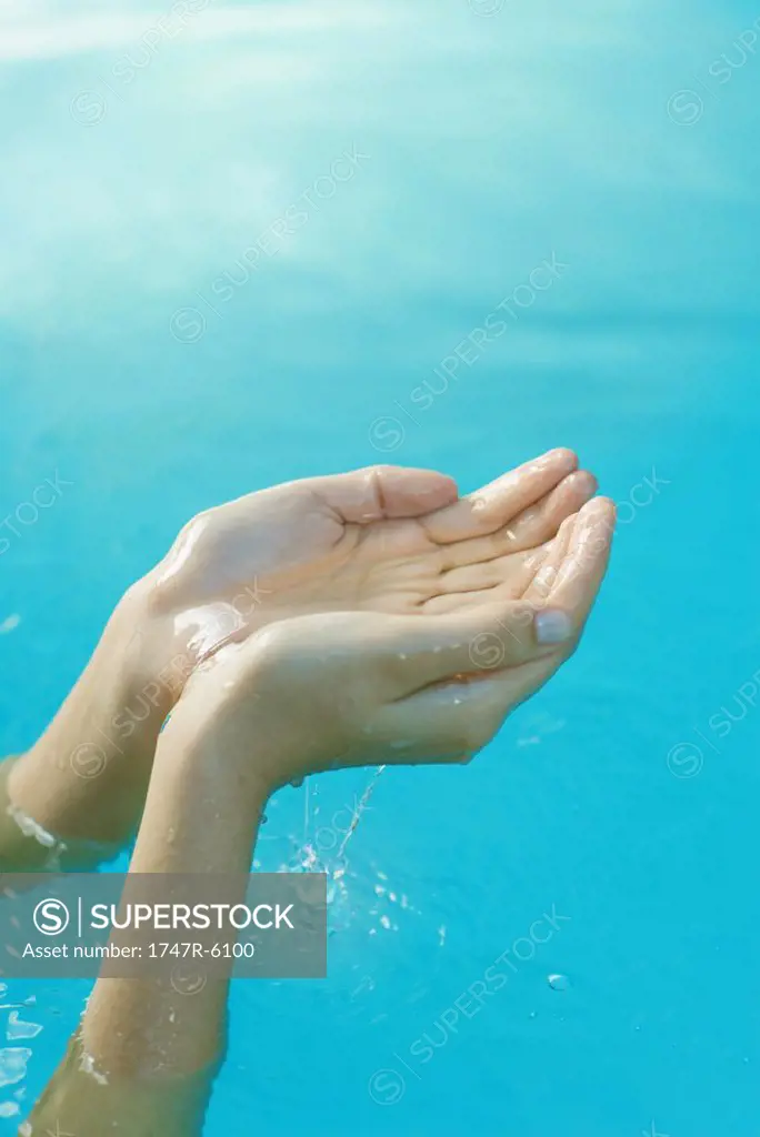 Young woman´s hands cupping water