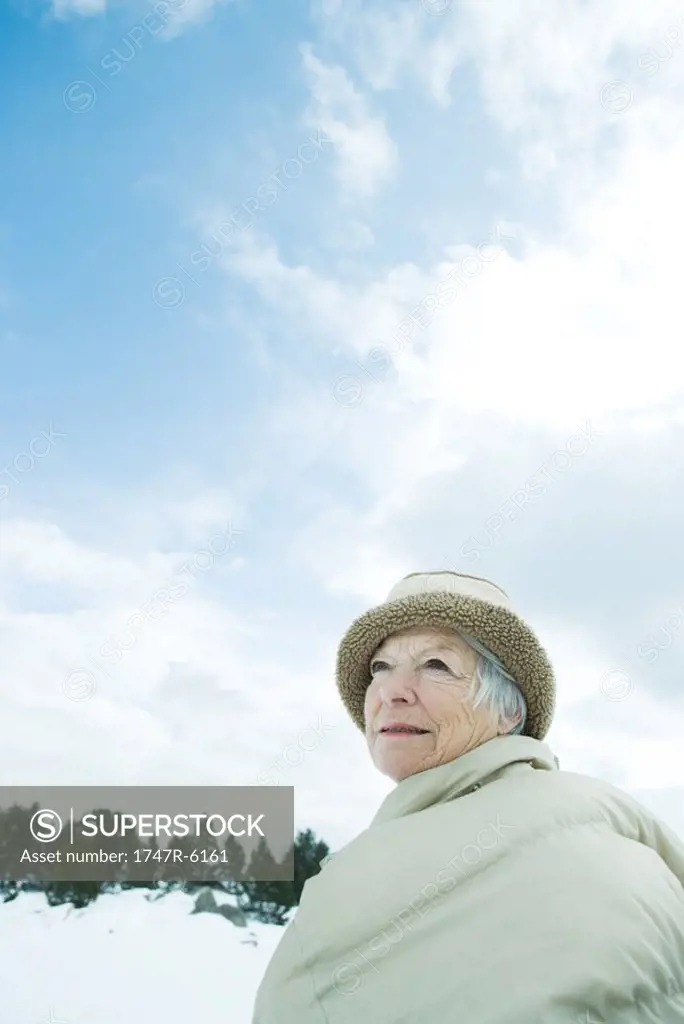 Senior woman standing in snowy landscape