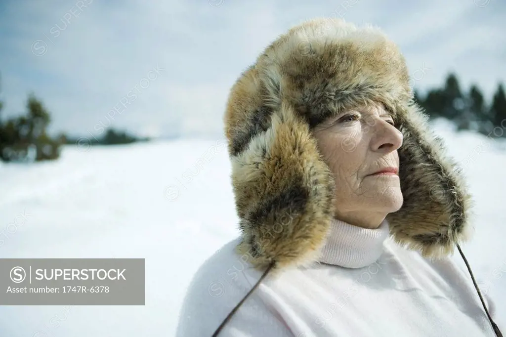 Senior woman standing in snowy landscape, head and shoulders