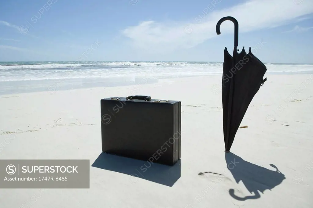 Umbrella and briefcase on beach