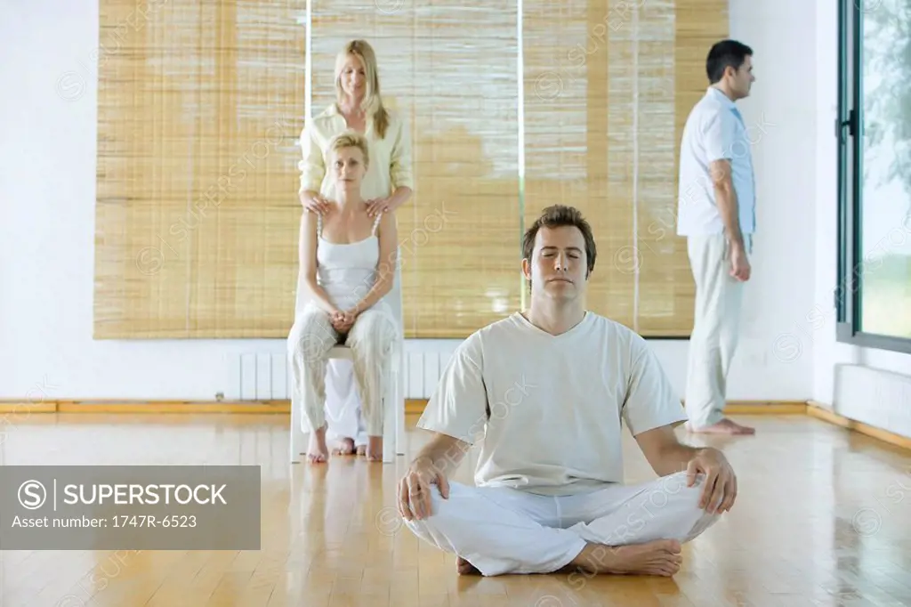 Four adults in various postures in wellness center