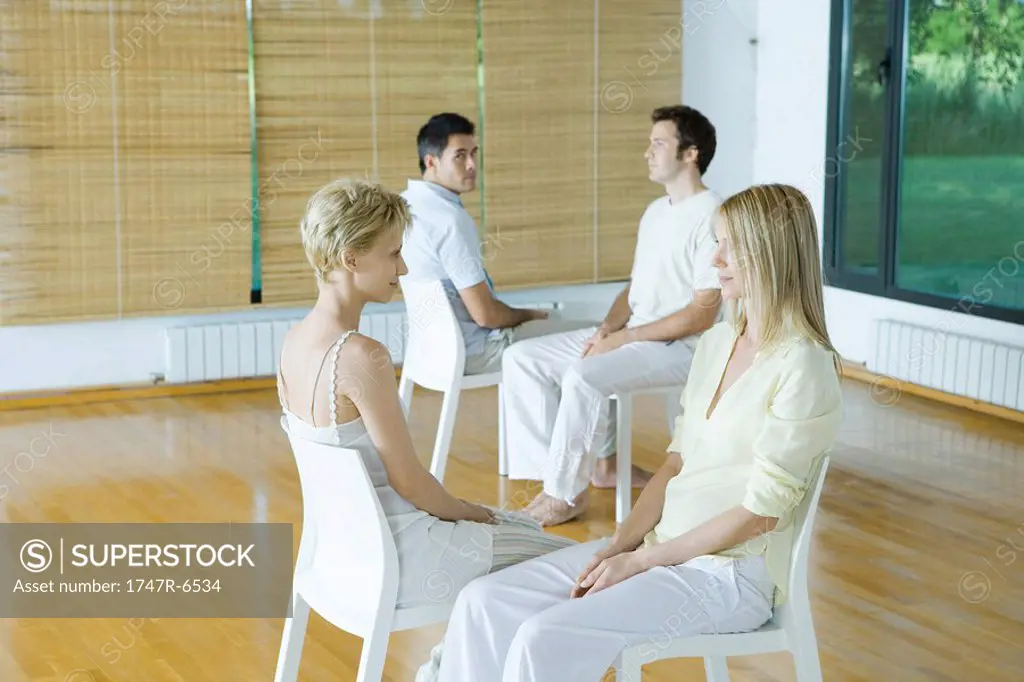 Two pairs of adults sitting together during therapy session