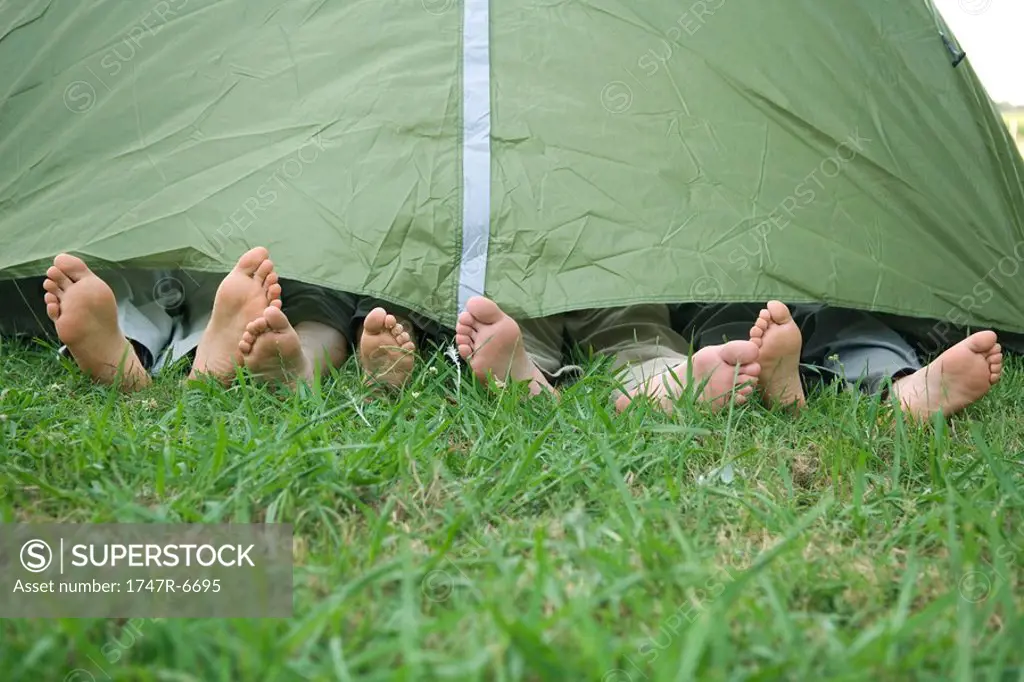Young friends in tent, feet sticking out