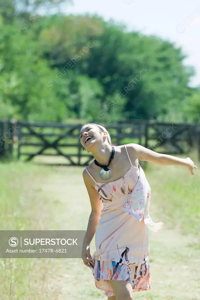 Young woman running on rural path with head back, eyes closed