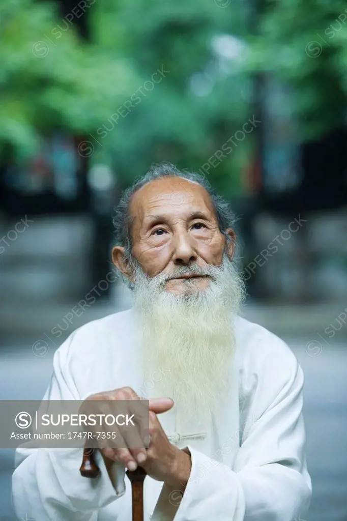 Elderly man wearing traditional Chinese clothing, holding cane